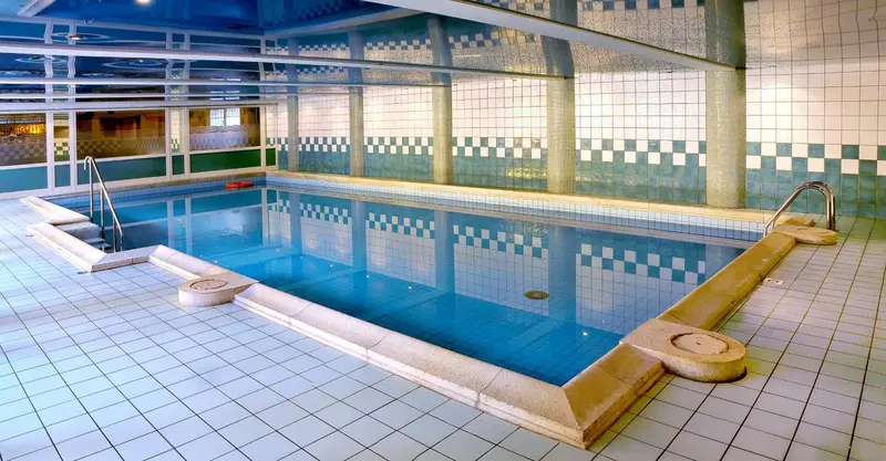 Une piscine rectangulaire carrelée avec des marches d'accès.