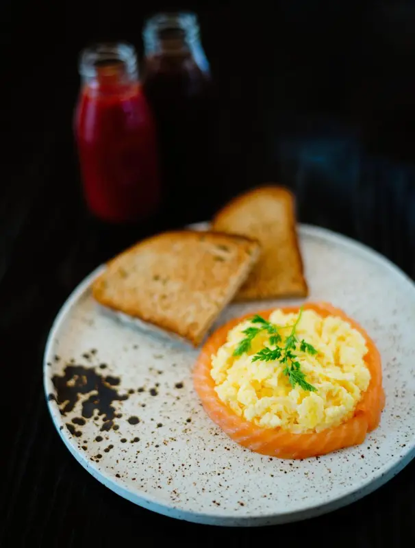 Assiette avec des œufs brouillés au saumon et des toasts.