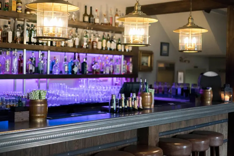 Un comptoir de bar illuminé propose une variété de boissons.