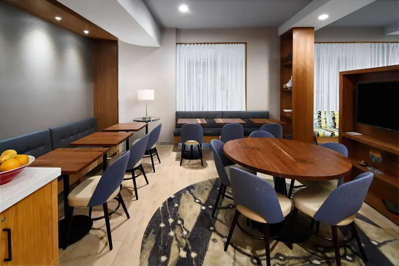 Une salle lumineuse avec des tables et des banquettes pour les repas.