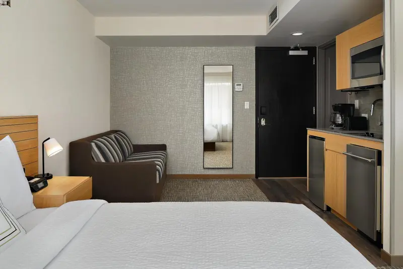 Une chambre avec un canapé et une kitchenette.