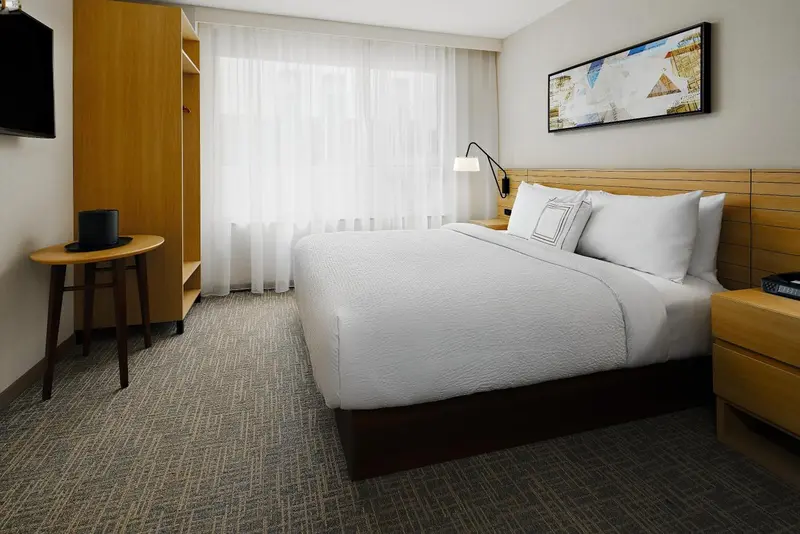 Une chambre lumineuse avec un grand lit et un mobilier en bois.