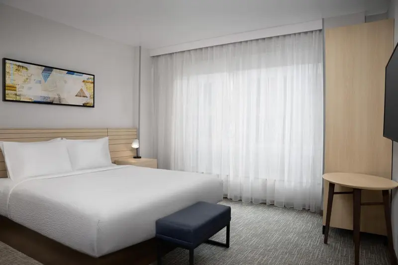 Une chambre lumineuse avec un grand lit et un espace détente.