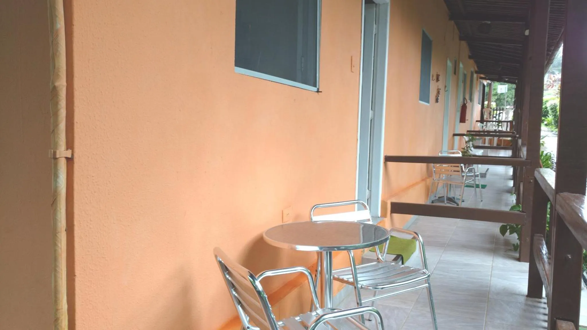 Terrasse avec table et chaises devant un mur orange.