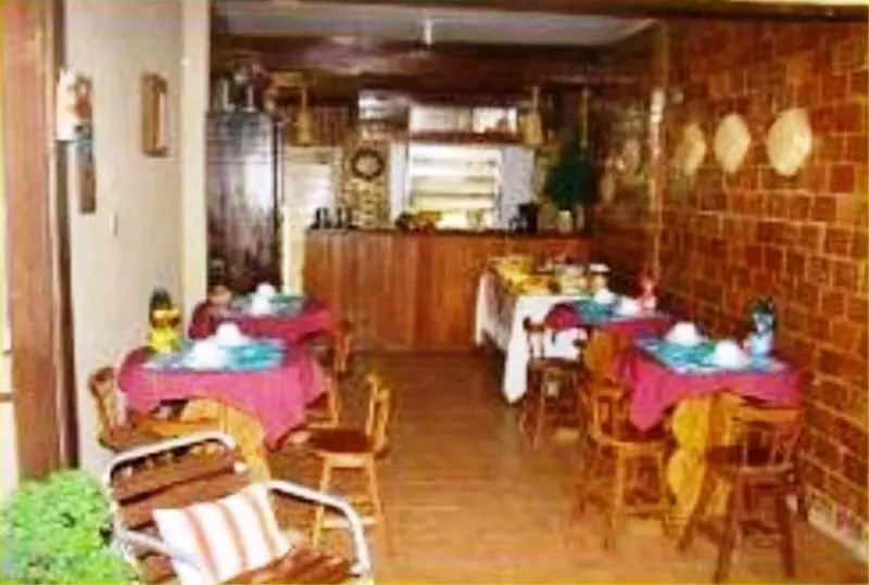 Une salle de restaurant avec des tables dressées et des chaises.