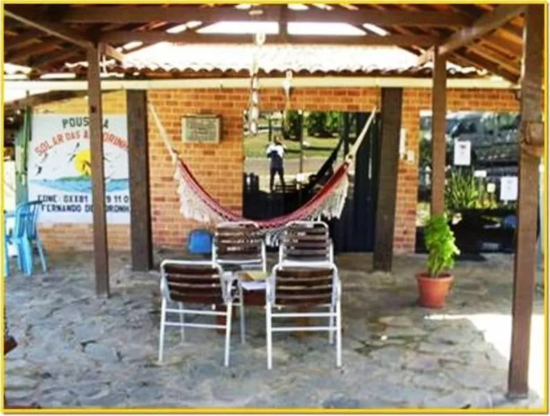 Espace de détente extérieur avec hamac et mobilier de jardin sous une pergola.