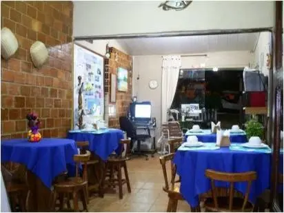 Une salle de restaurant avec des tables bleues et des chaises en bois.