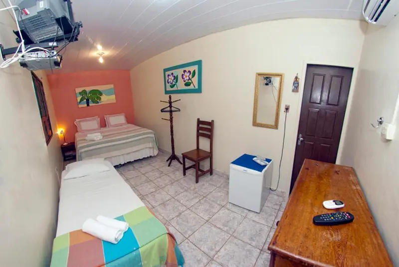 Une chambre lumineuse avec un lit double et un lit simple.