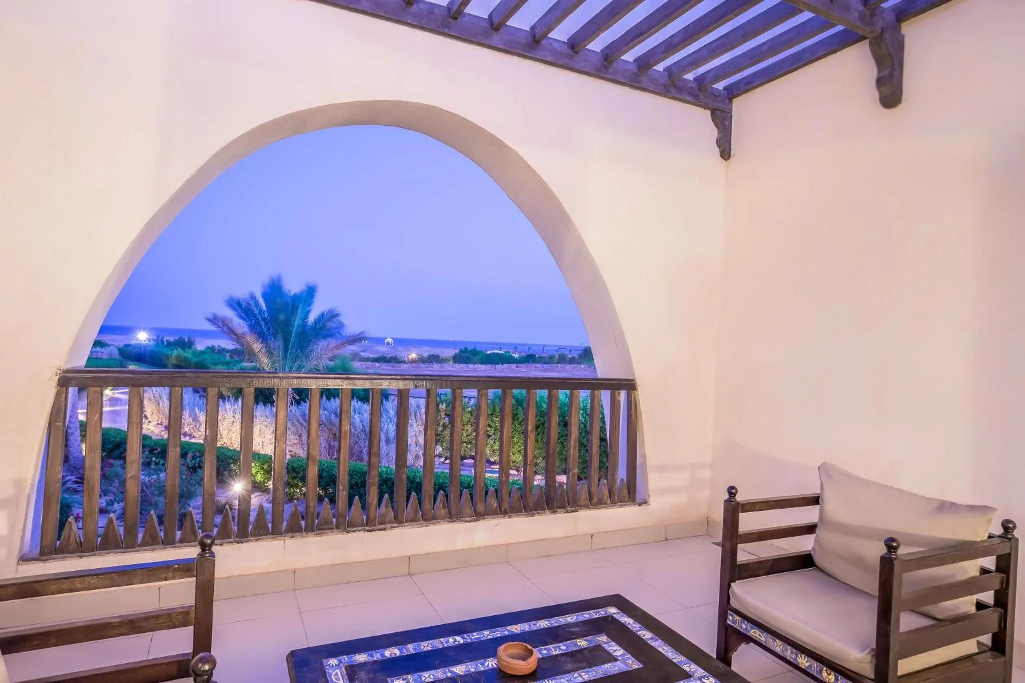 Vue sur la mer depuis une terrasse ombragée.