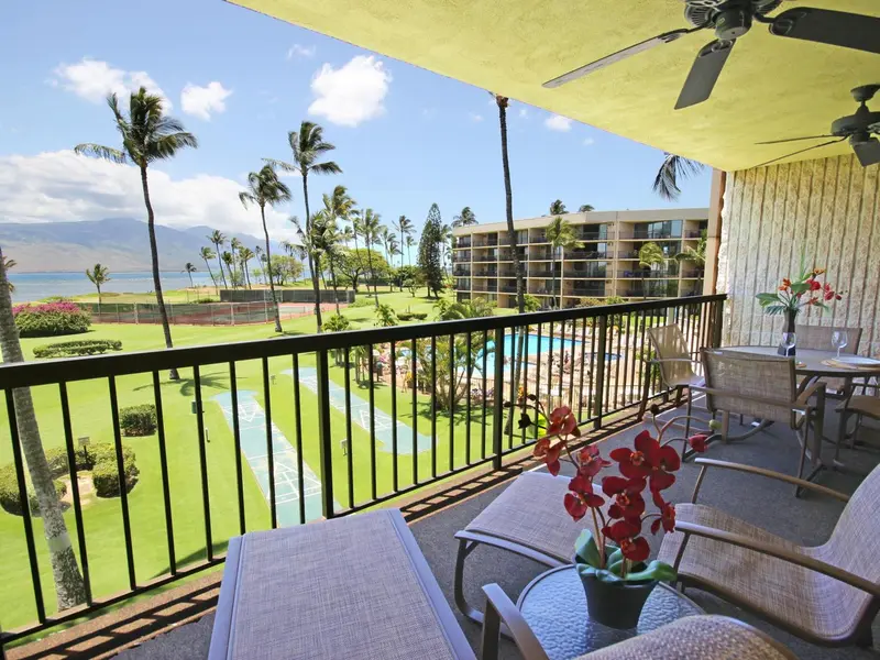 Terrasse avec mobilier de jardin et vue sur un paysage tropical.