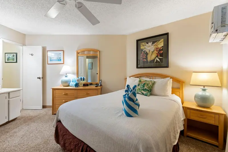 Une chambre lumineuse avec un lit double et une commode.