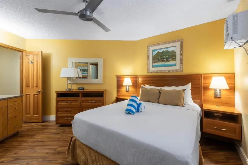 Une chambre lumineuse avec un grand lit et des meubles en bois.