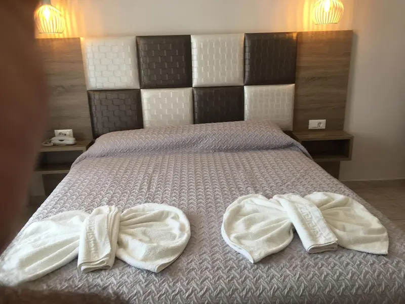 Lit double préparé avec des serviettes en forme de cygnes sur le couvre-lit.
