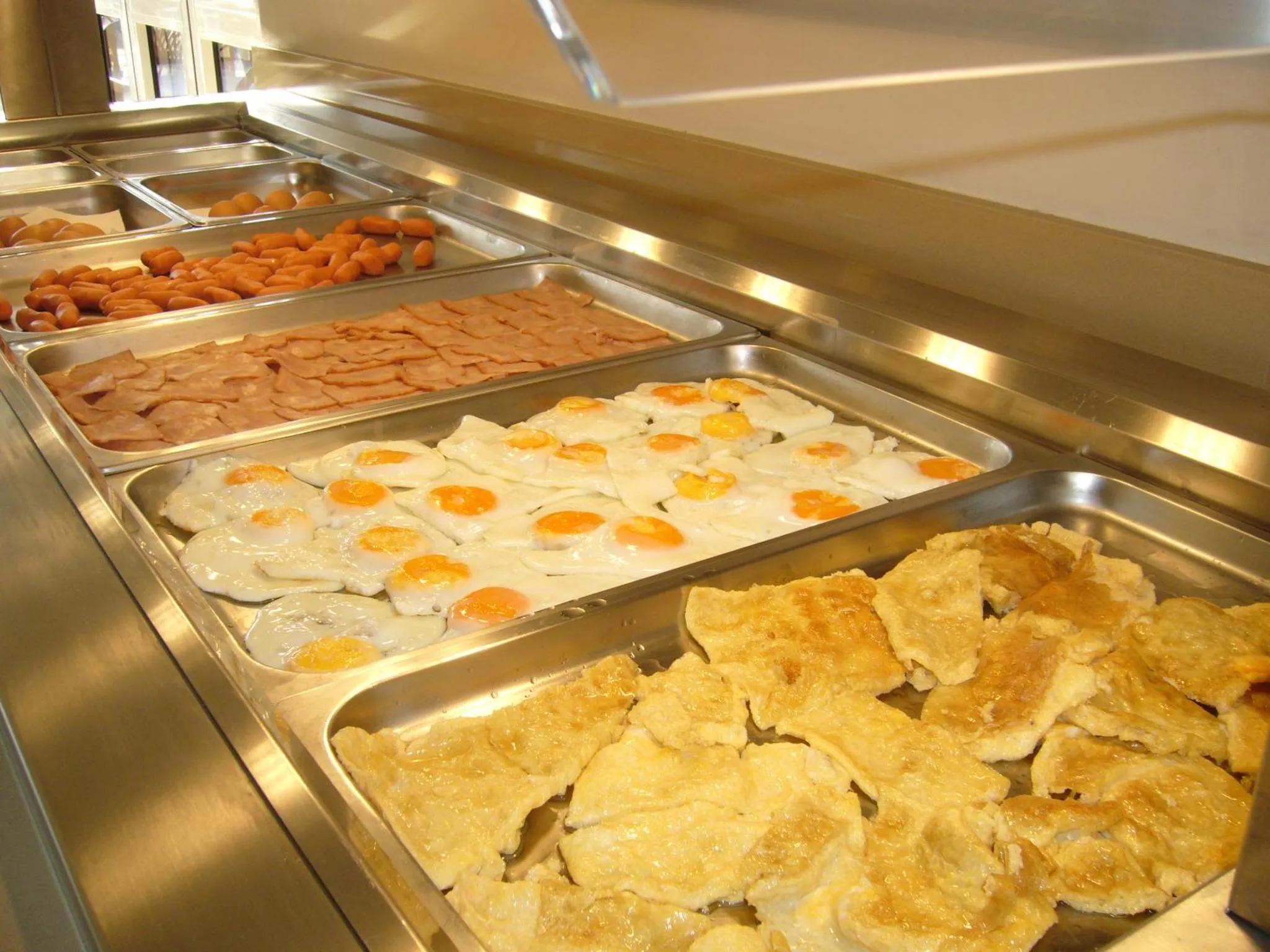 Un buffet propose une selection de plats chauds pour le petit-dejeuner.