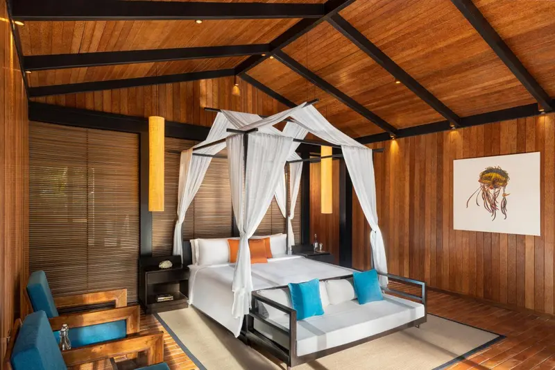 Une chambre lumineuse avec un lit à baldaquin et une décoration en bois.