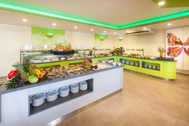 Un buffet garni de plats variés est présenté dans une salle lumineuse.