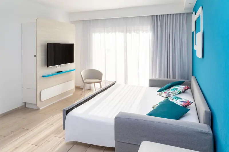 Une chambre lumineuse avec un lit et un canapé.
