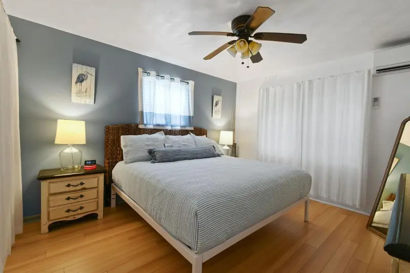 Une chambre lumineuse avec un grand lit et des meubles en bois.
