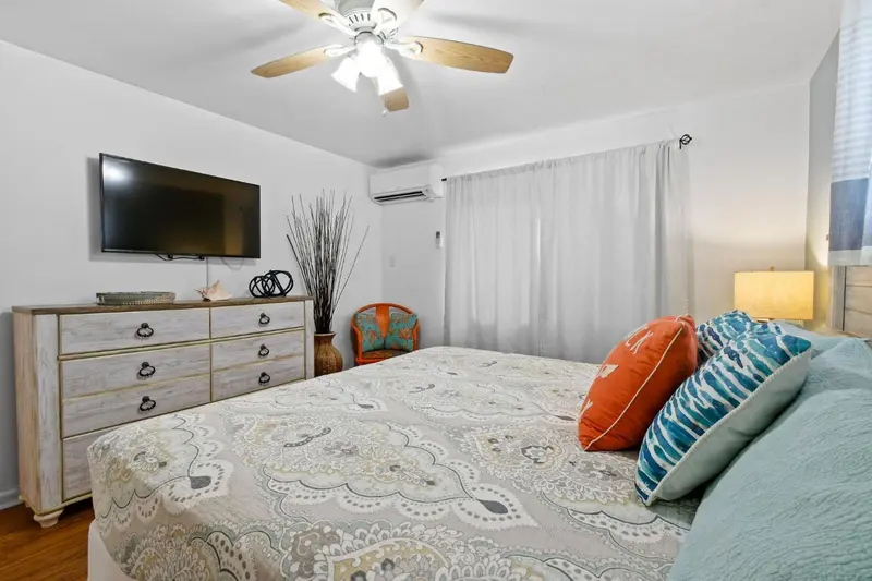 Une chambre lumineuse avec un grand lit recouvert d'une courtepointe décorative.
