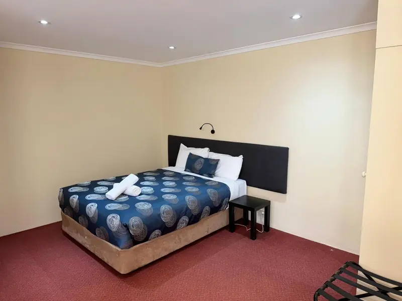 Une chambre avec un lit double et une table de chevet.