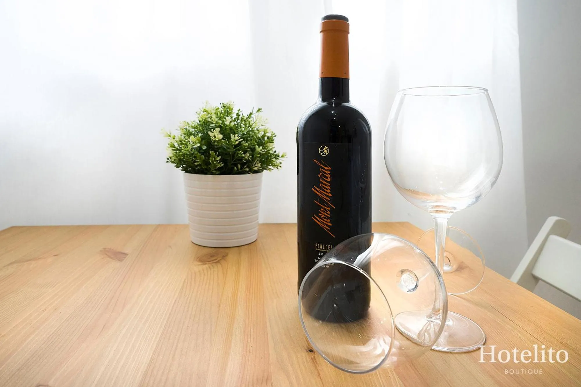 Une bouteille de vin et des verres sur une table en bois.