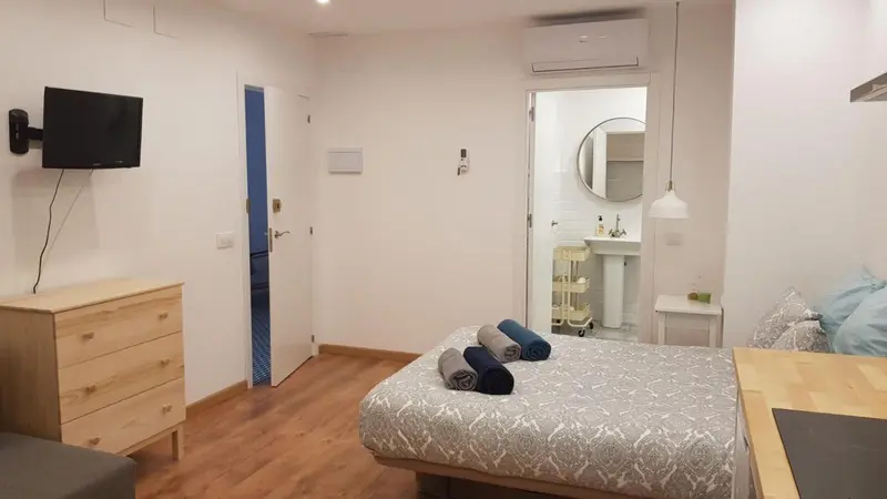 Une chambre lumineuse avec un lit et une commode en bois.