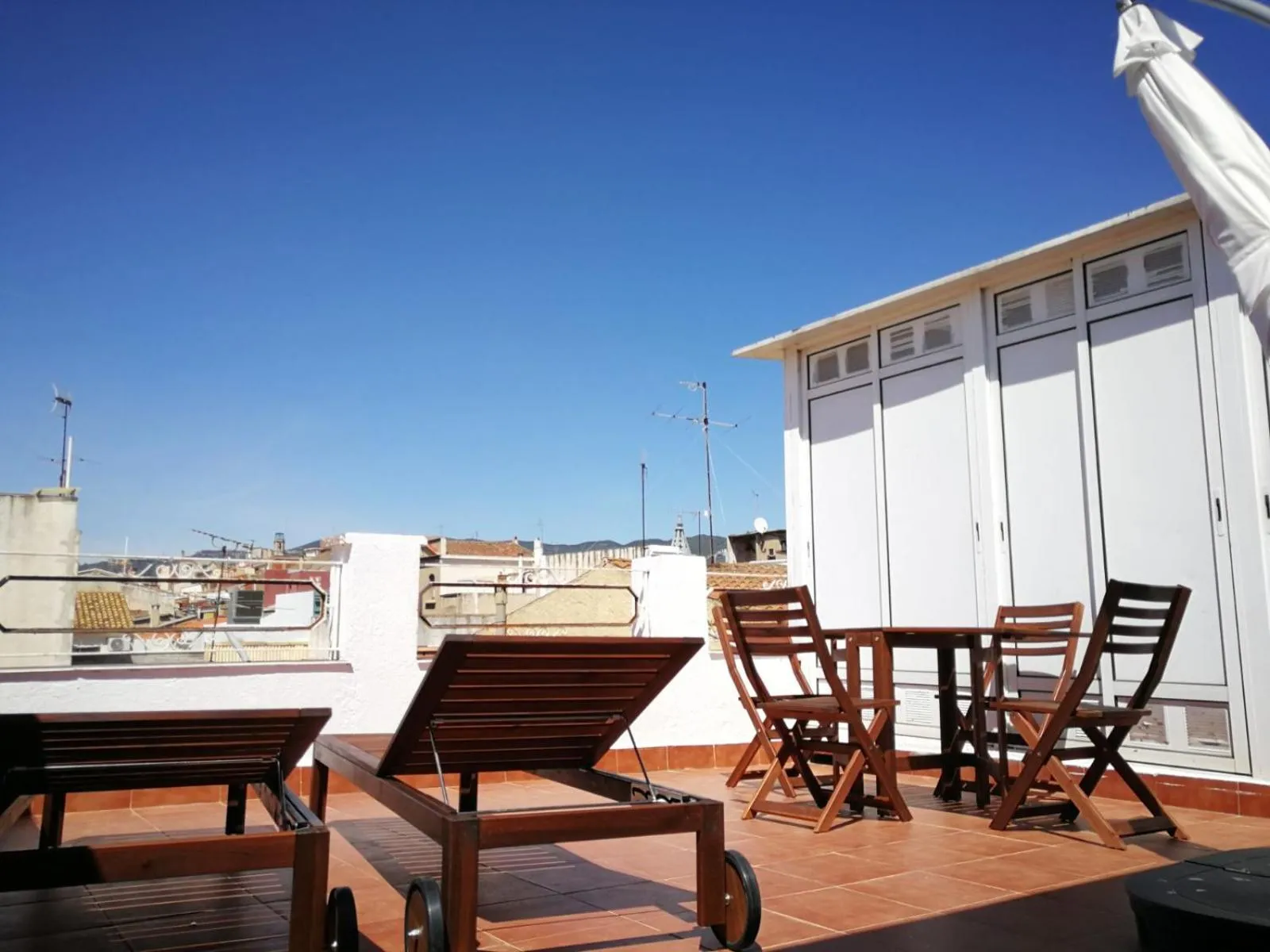 Terrasse aménagée avec chaises longues et mobilier de jardin.