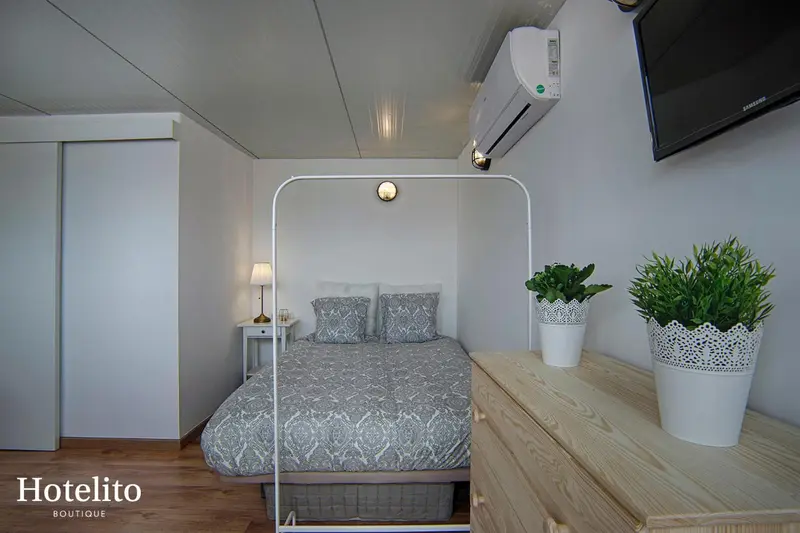 Une chambre lumineuse avec un lit double et une décoration sobre.