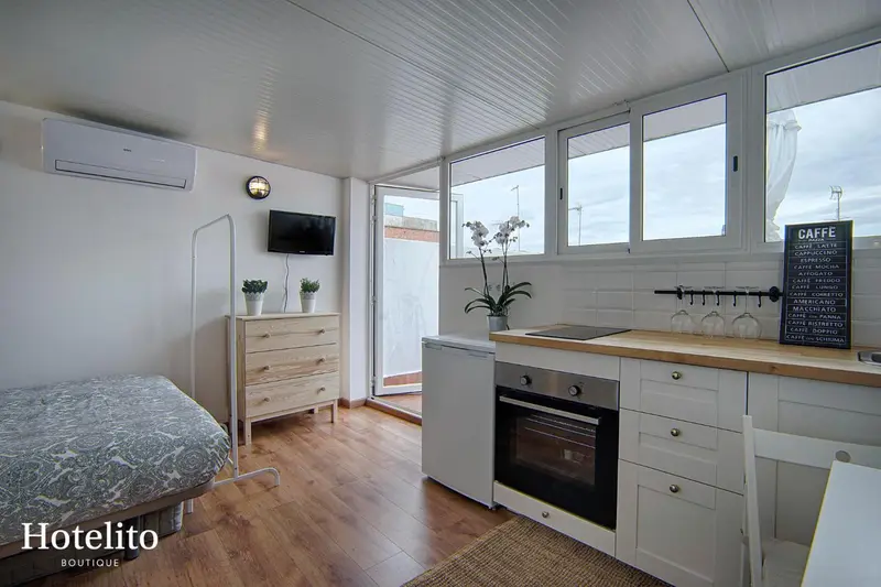 Une kitchenette lumineuse avec un plan de travail en bois et des équipements modernes.