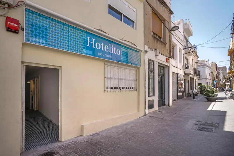 Façade d'un petit hôtel avec une devanture bleue et blanche.