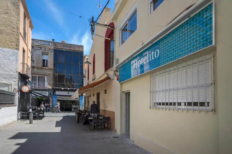 Façade d'un bâtiment beige avec une devanture bleue et blanche dans une rue.