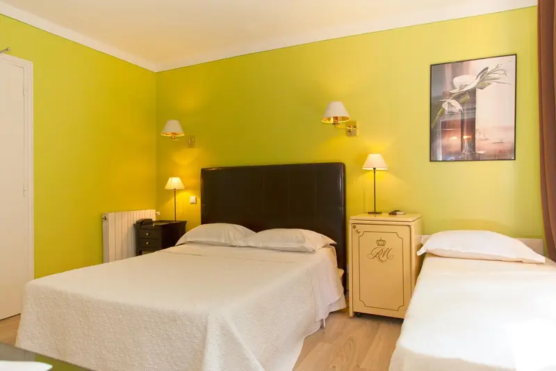 Une chambre lumineuse avec un grand lit et une décoration sobre.