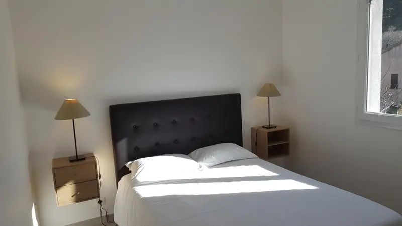 Une chambre lumineuse avec un grand lit et des lampes de chevet.