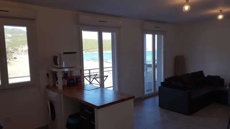Interieur lumineux avec cuisine et espace salon donnant sur une vue mer.
