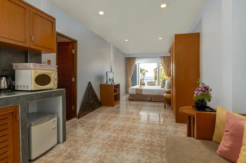 Une cuisine équipée s'ouvre sur une chambre avec un lit et un coin salon.