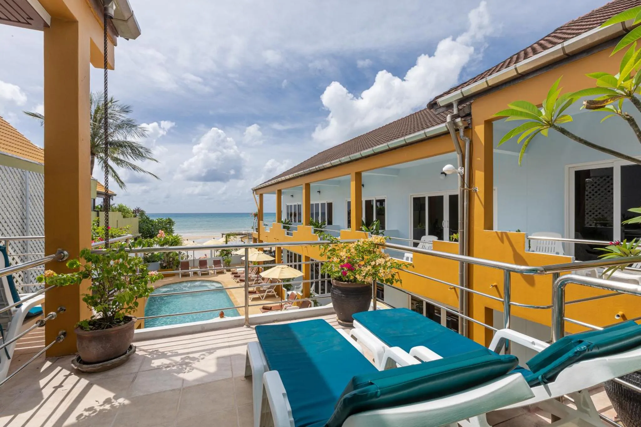 Terrasse ensoleillée avec transats et piscine face à la mer.