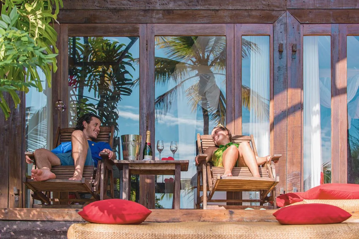 Deux personnes se relaxent sur des transats face à la mer.