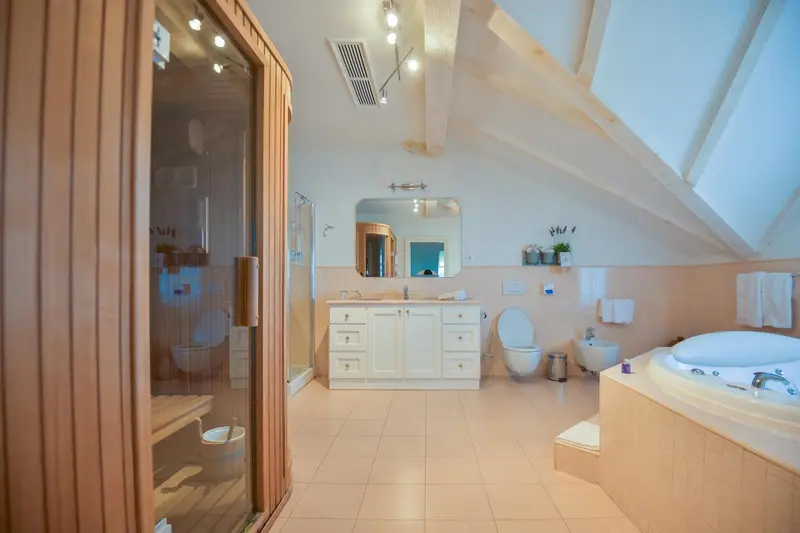 Une salle de bain lumineuse avec douche vitrée et baignoire à remous.
