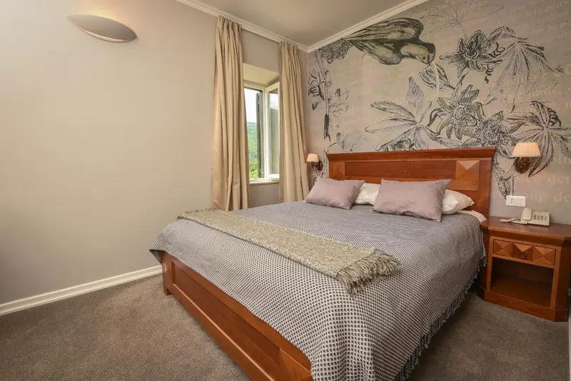 Une chambre avec un grand lit recouvert d'une couverture et de coussins.