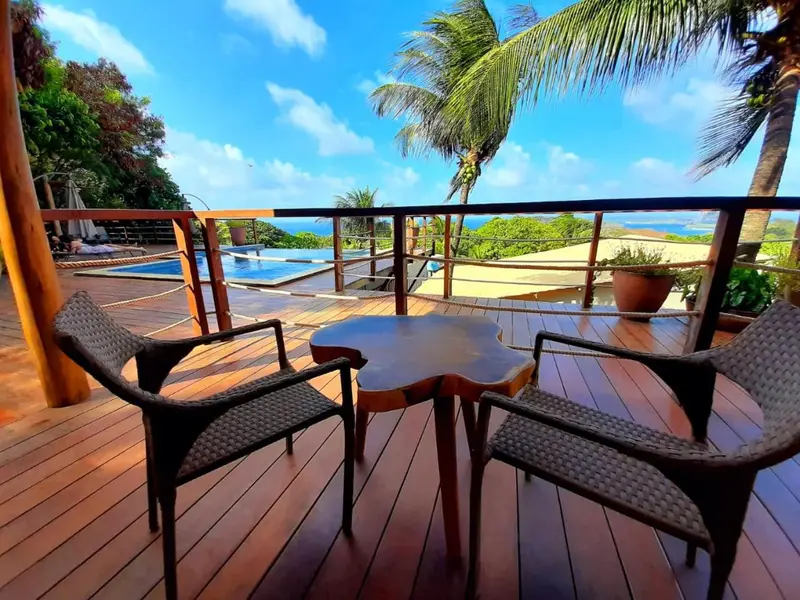 Terrasse en bois avec mobilier de jardin et vue sur la mer.