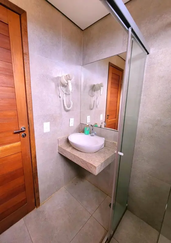 Une salle de bain lumineuse avec un lavabo et une douche à l'italienne.