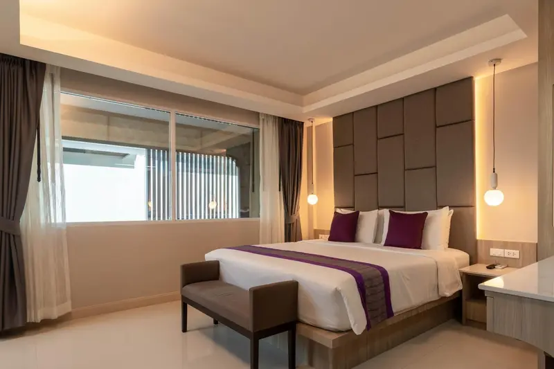 Chambre lumineuse avec un grand lit et une décoration moderne.