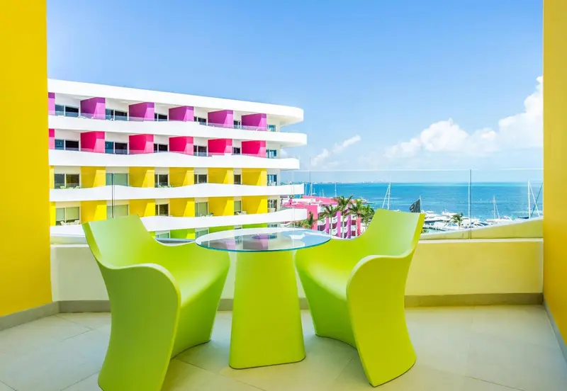 Terrasse colorée avec mobilier d'extérieur et vue sur la mer.