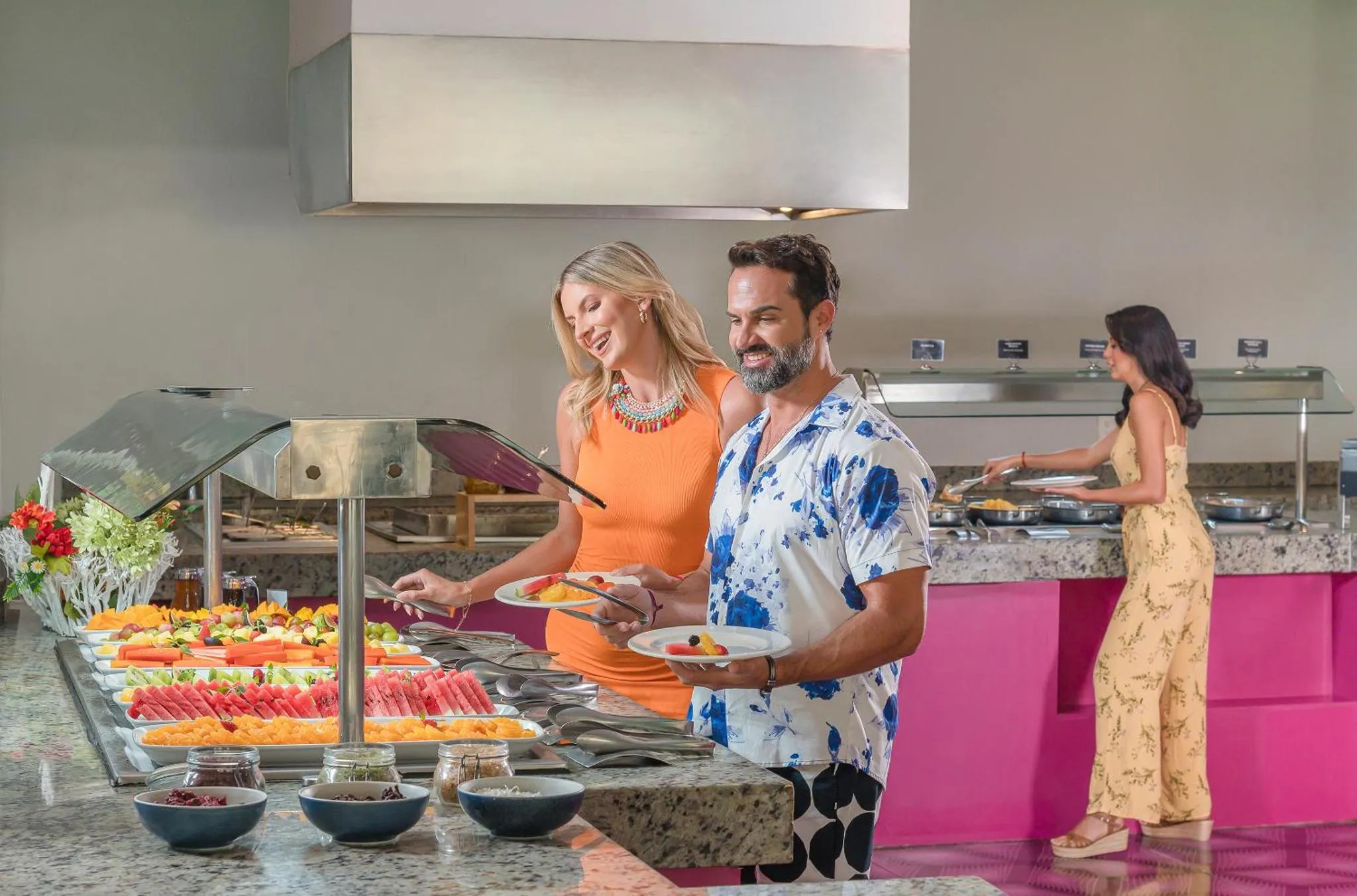 Un couple souriant se sert au buffet d'un restaurant.