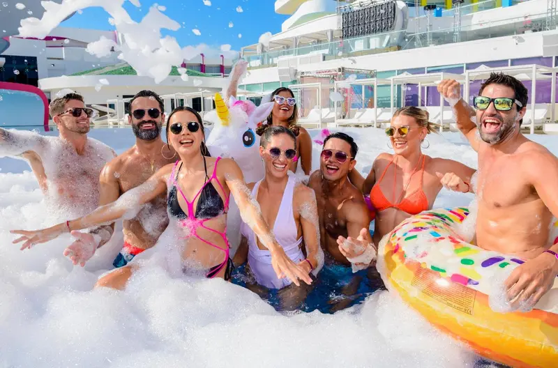 Un groupe de personnes s'amuse dans une piscine à mousse ensoleillée.