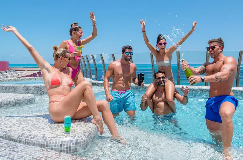 Un groupe de personnes s'amuse dans une piscine en bord de mer.