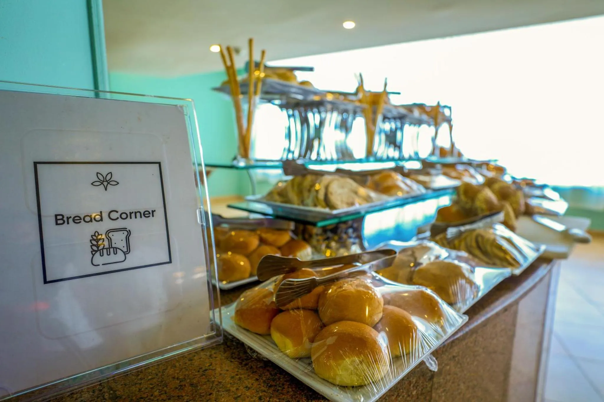 Un buffet propose une variété de viennoiseries et de pains.