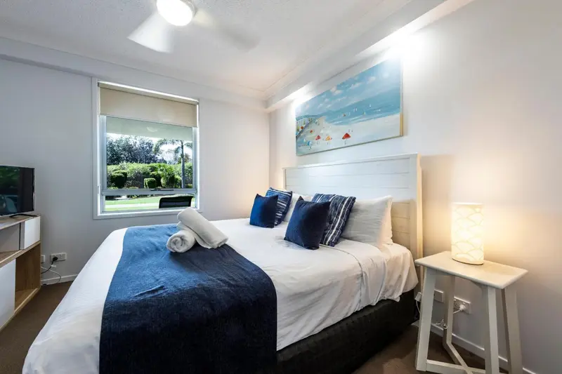 Une chambre lumineuse avec un grand lit et une décoration marine.