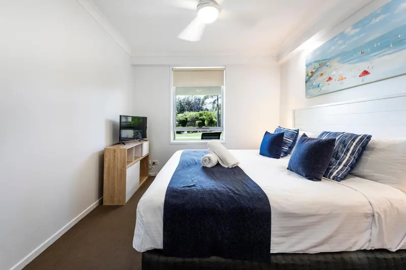 Une chambre lumineuse avec un grand lit et une décoration marine.