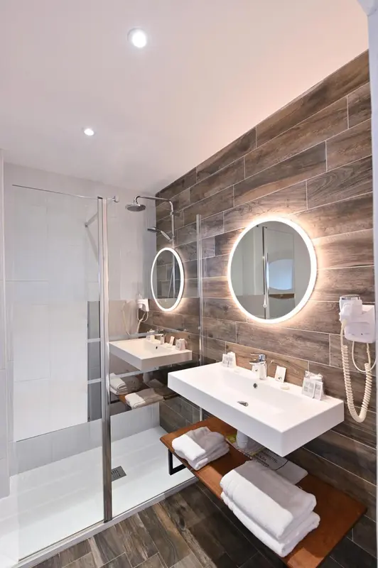 Une salle de bain moderne avec douche à l'italienne et vasques sur plan.